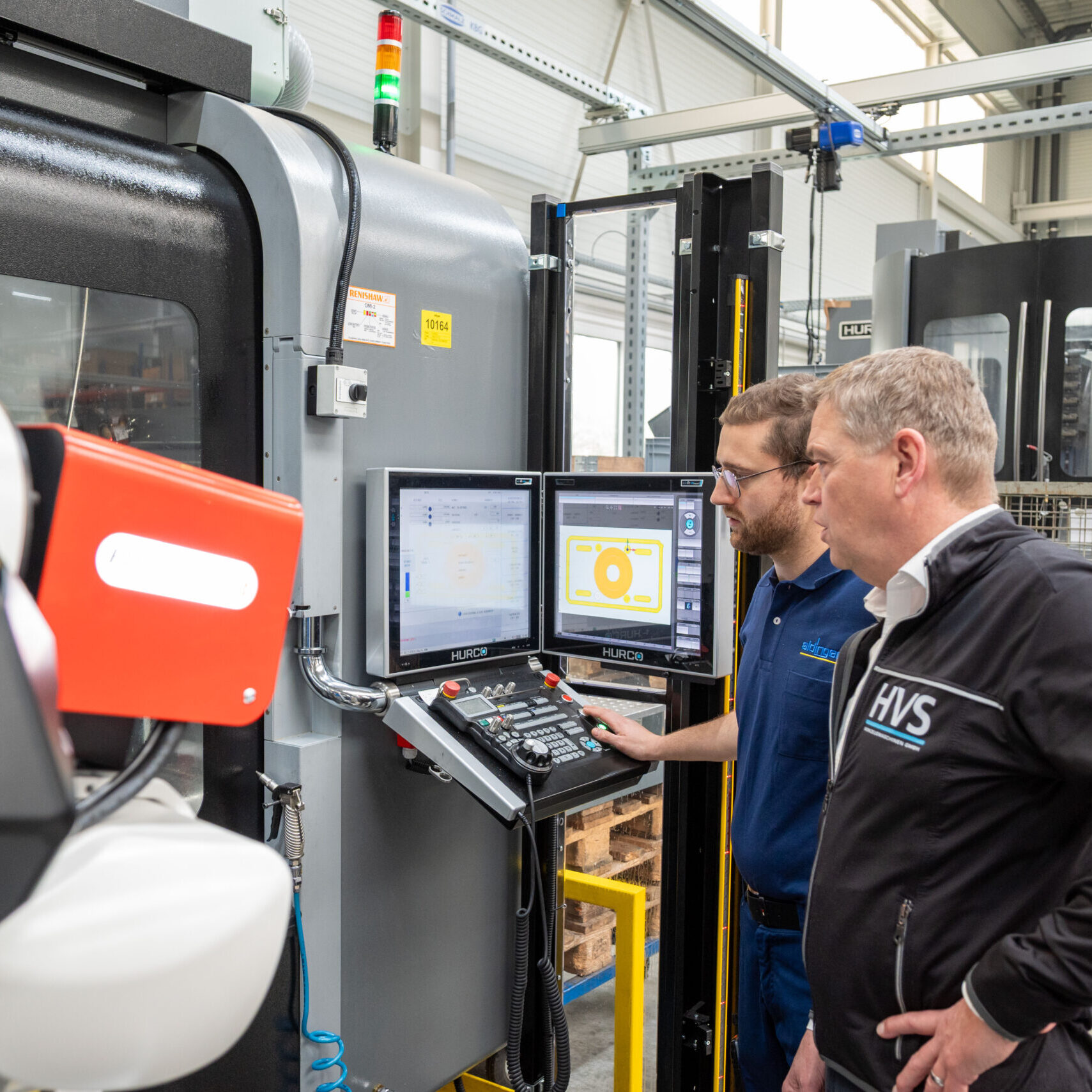 Thomas Schunn und Thomas Bär vor den beiden Bildschirmen der HURCO-Steuerung