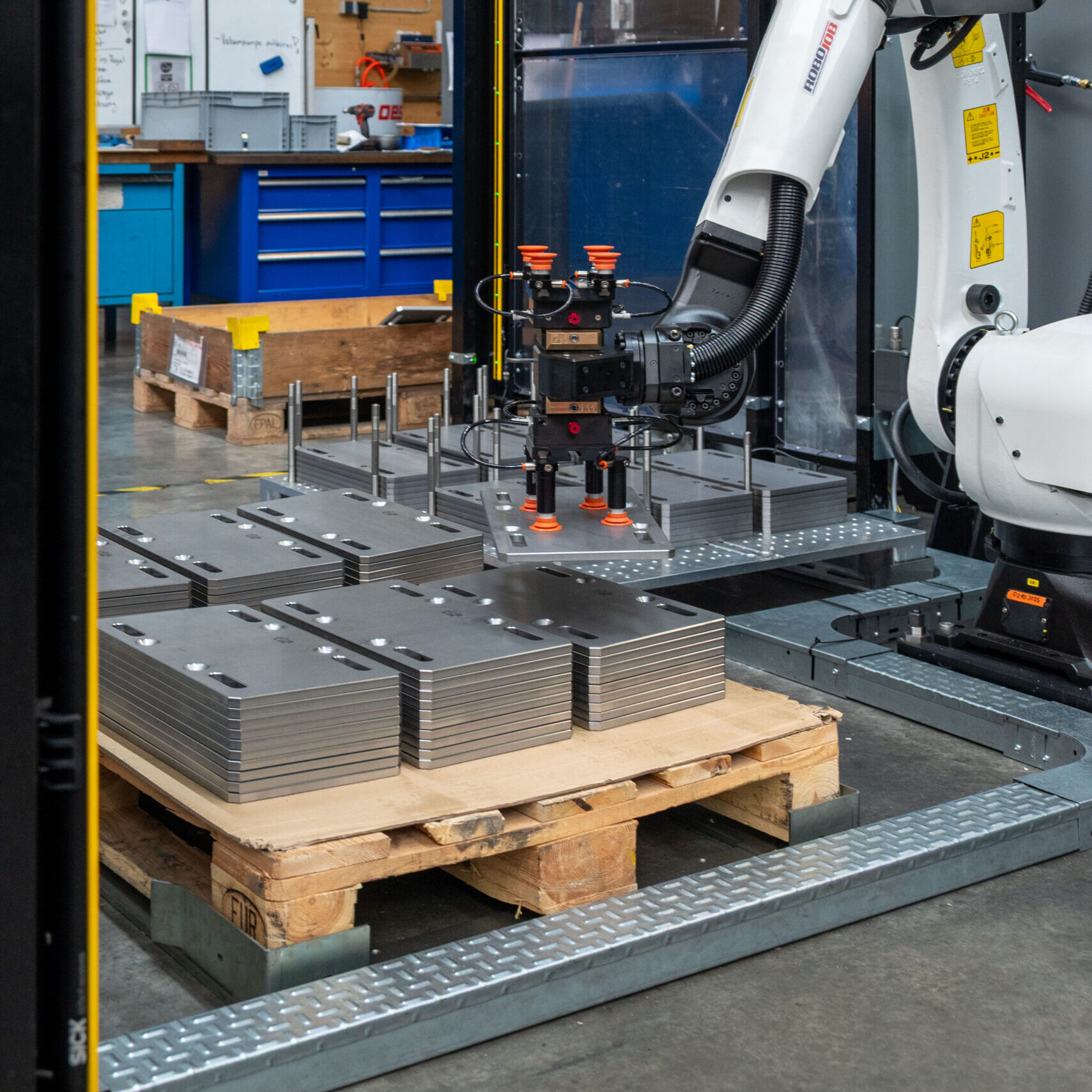 RoboJob-Roboter legt ein fertig bearbeitetes Werkstück auf der Palette ab