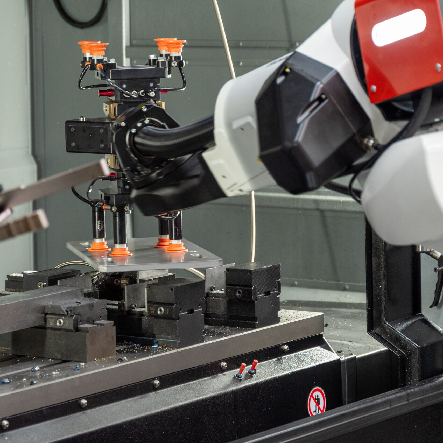 RoboJob-Roboter positioniert ein schweres Werkstück exakt in der HURCO-Maschine