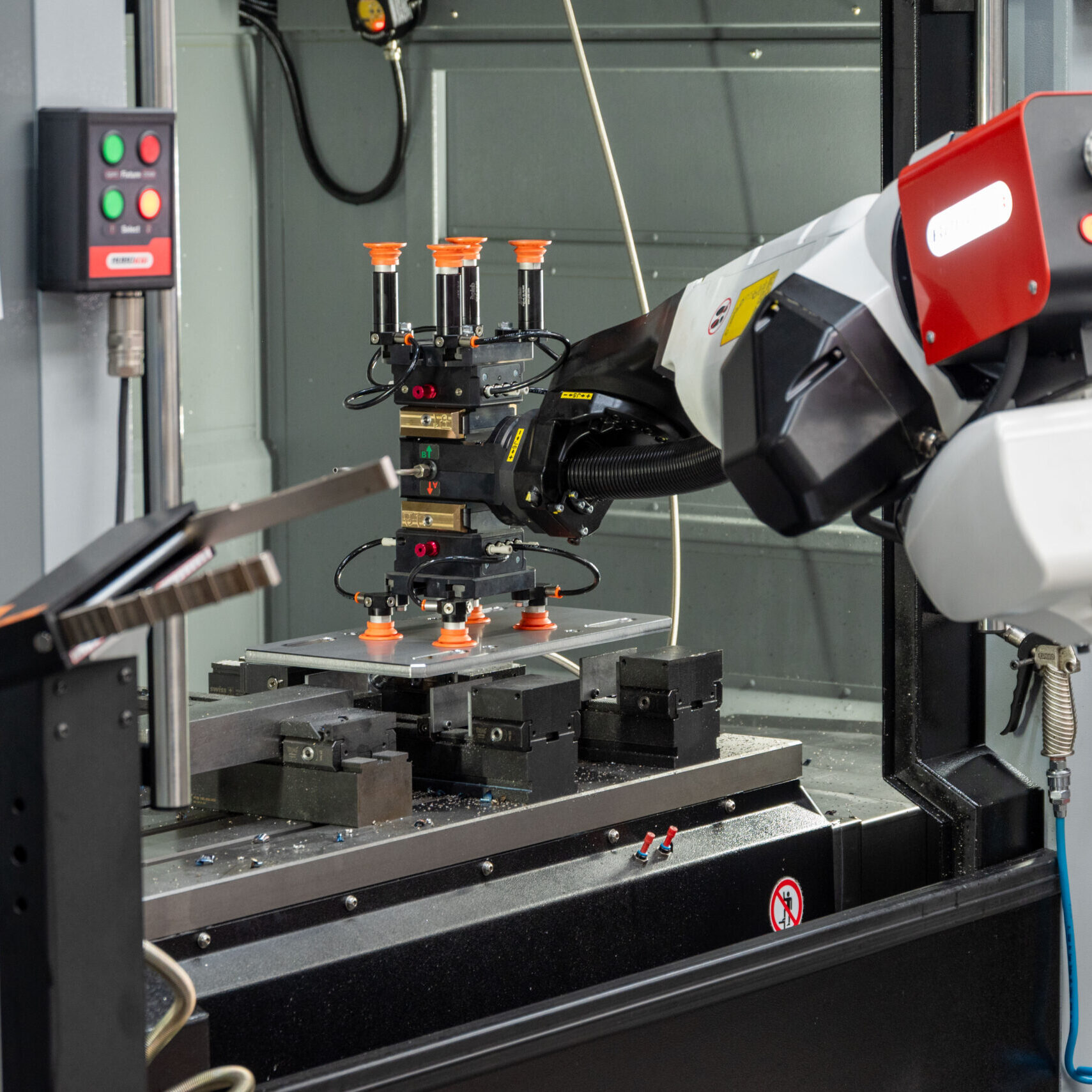 Wendestation im Vordergrund, RoboJob-Roboter wendet ein bearbeitetes Werkstück