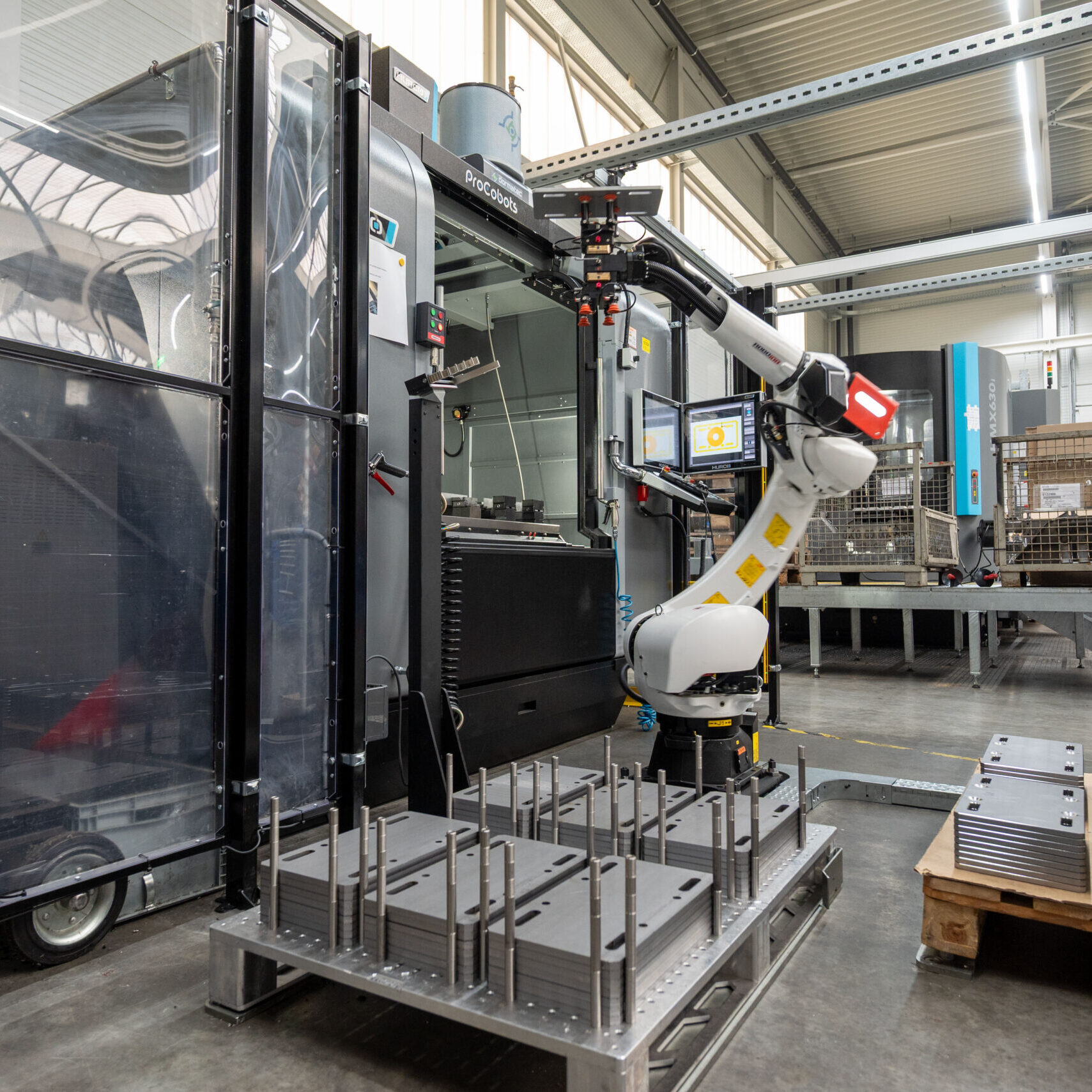 HURCO-Anlage mit RoboJob-Roboter und zwei Paletten – Roboter entnimmt ein zu bearbeitendes Werkstück