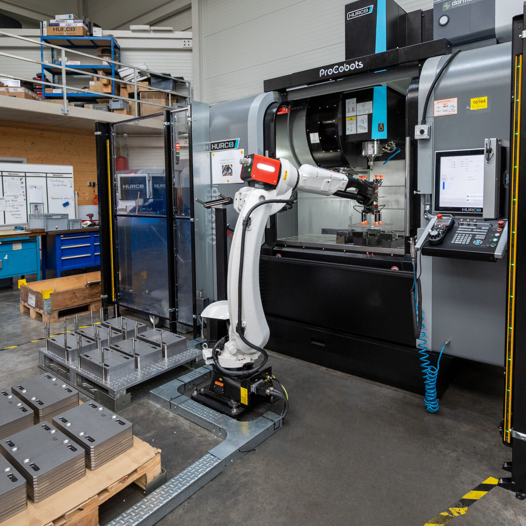 RoboJob-Roboter legt ein Werkstück in ein HURCO-Bearbeitungszentrum ein