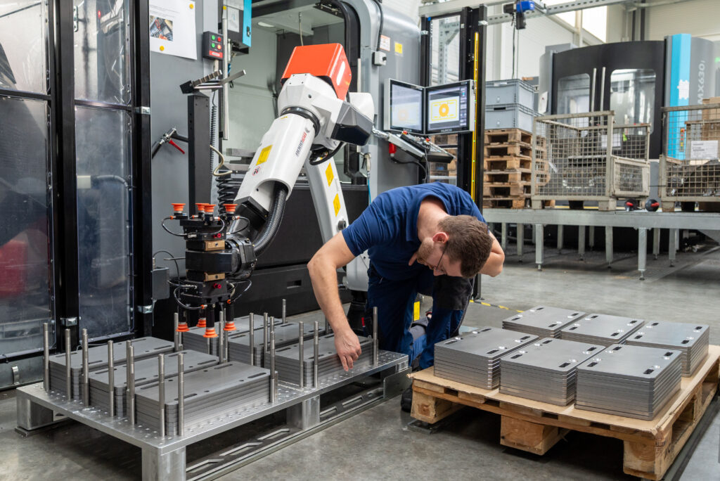 Thomas Schunn prüft Stahlplatten auf einer Palette vor dem automatisierten Bearbeitungsprozess