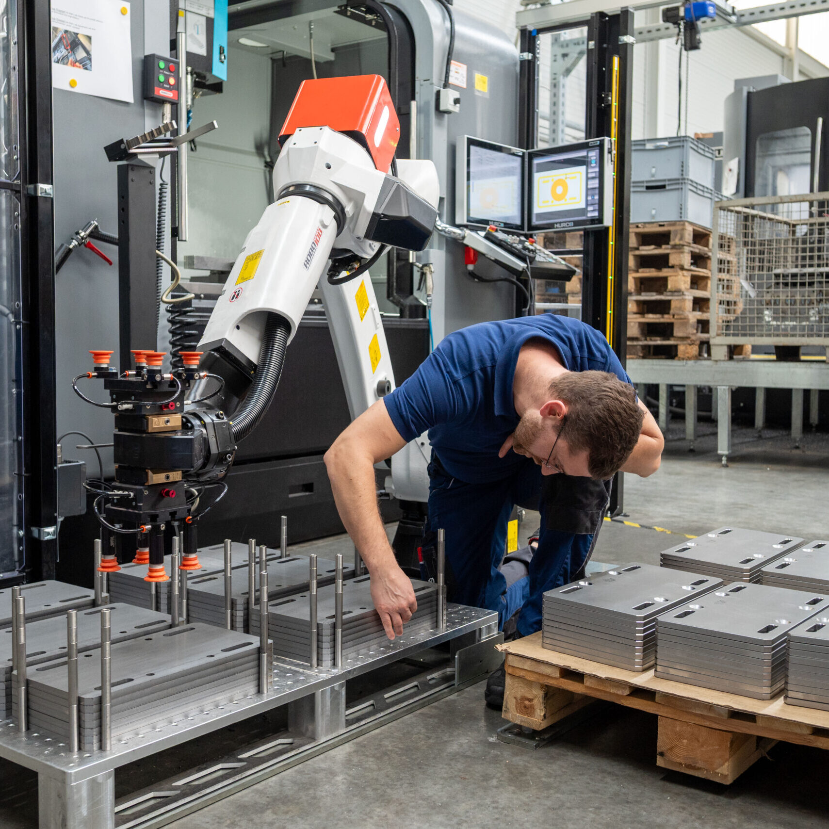 Thomas Schunn prüft Stahlplatten auf einer Palette vor dem automatisierten Bearbeitungsprozess