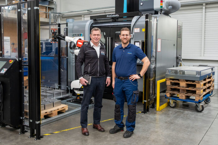 Thomas Bär (links) und Thomas Schunn vor einer Automationszelle mit Roboterhandling und Wendestation an einem 3-Achs-Bearbeitungszentrum